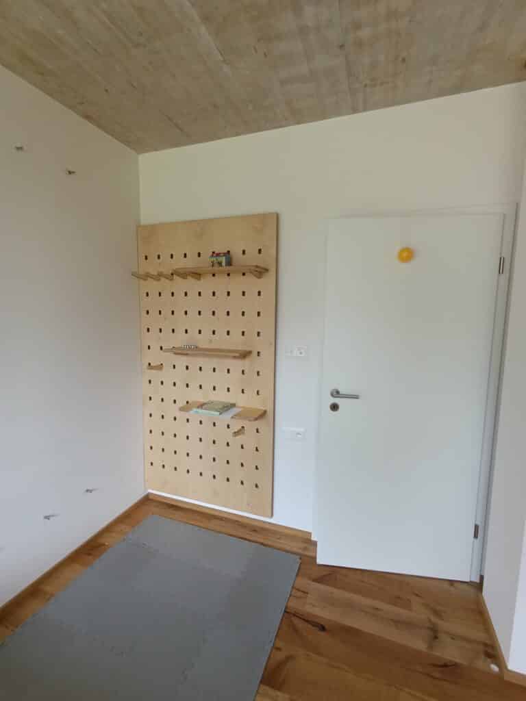 nástěnný pegboard osazený poličkami a březové překližky